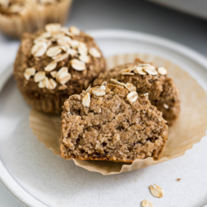 Half of a banana applesauce muffin on a plate.