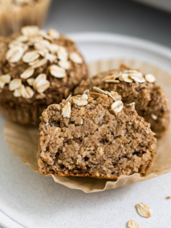 Half of a banana applesauce muffin on a plate.