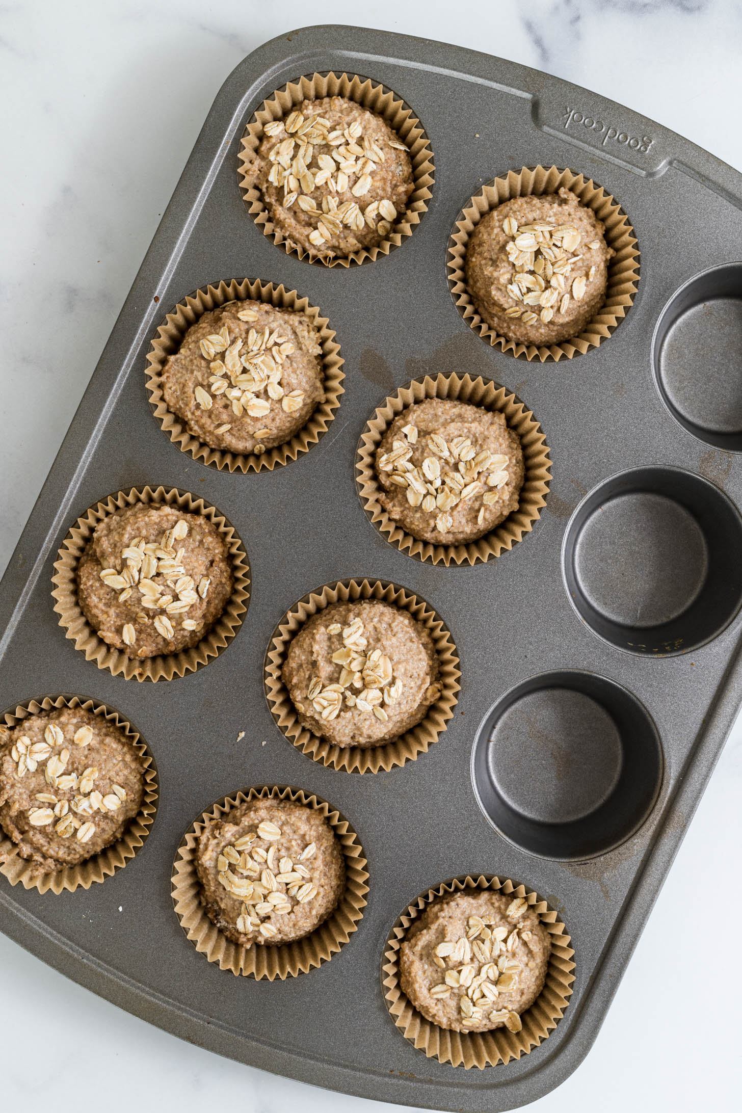 Uncooked muffins in a muffin pan.