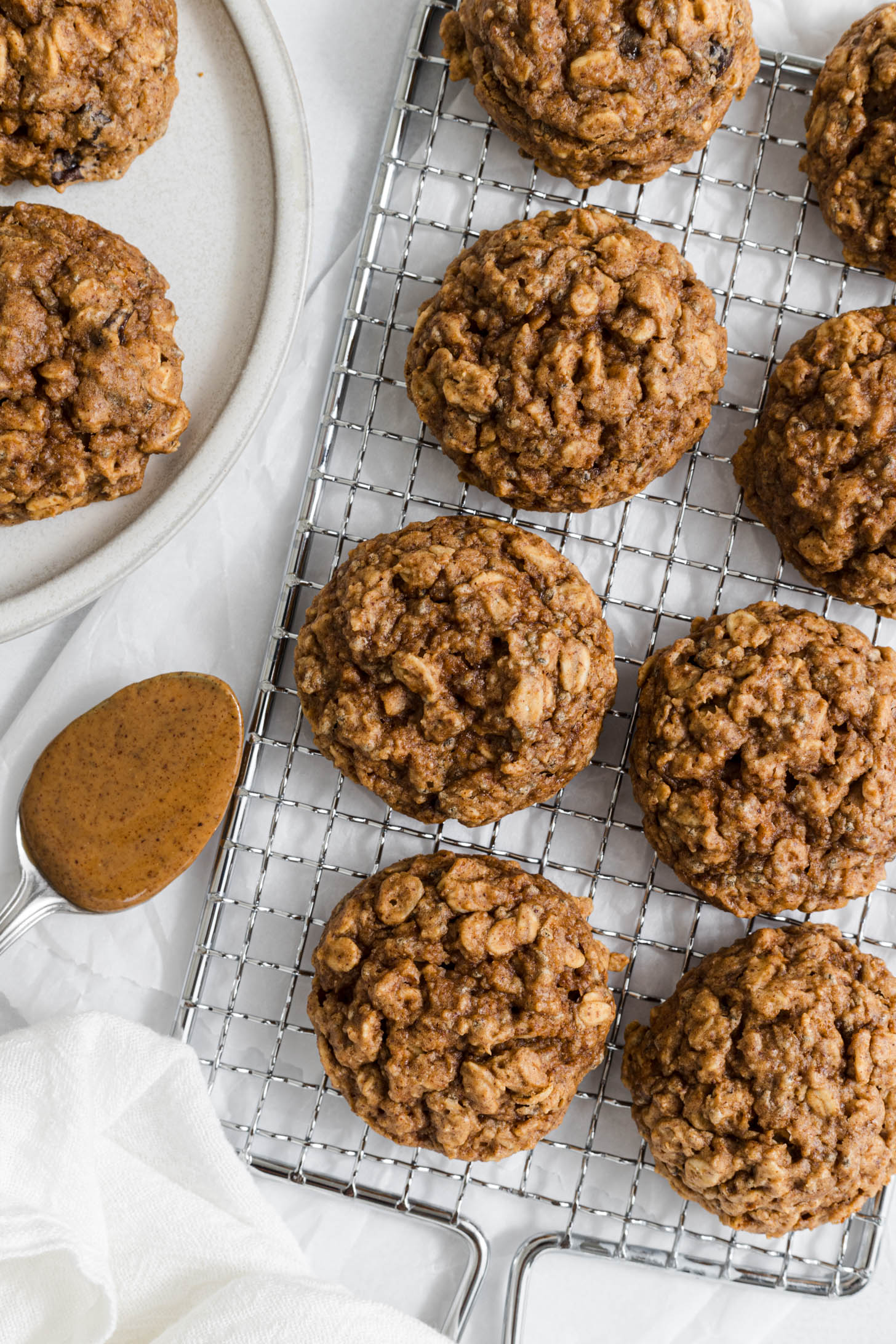 Almond butter cookies on a wire rack with a spoonful of almond butter next to them.