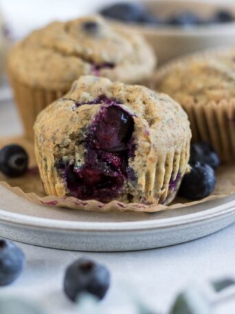 A blueberry muffin with a bite out of it.