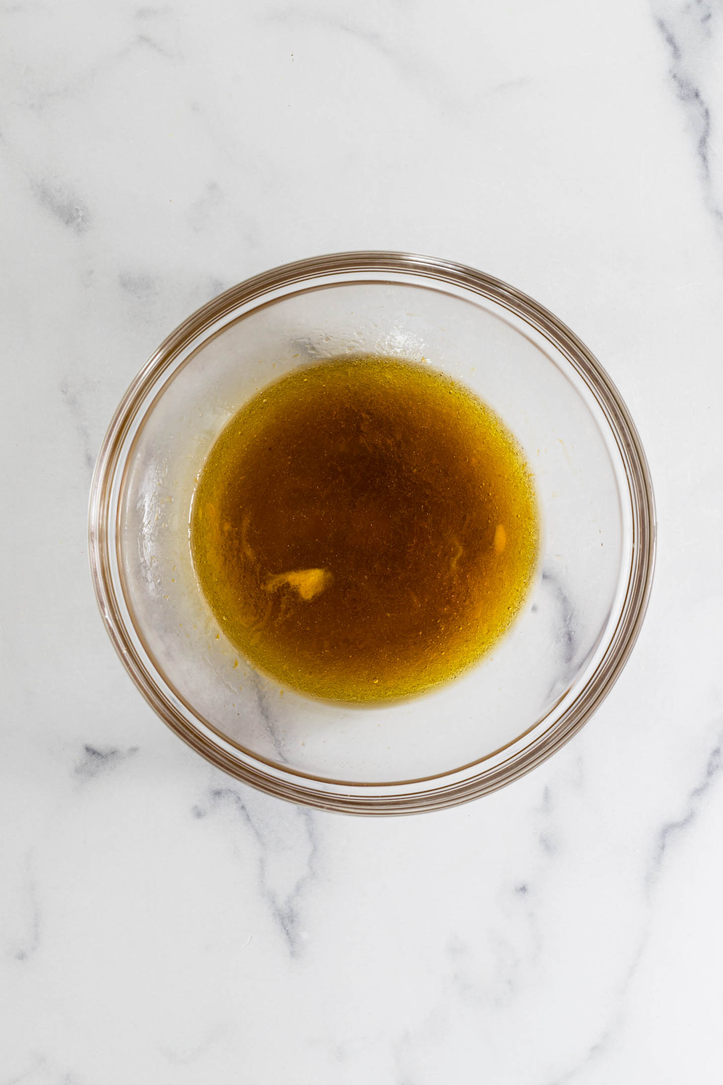 Wet ingredients combined in a glass mixing bowl.