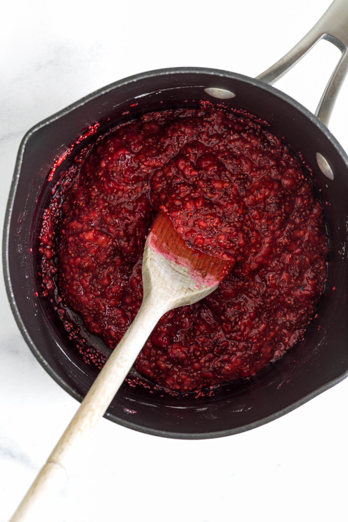 Cooked down raspberry jam in a pot.