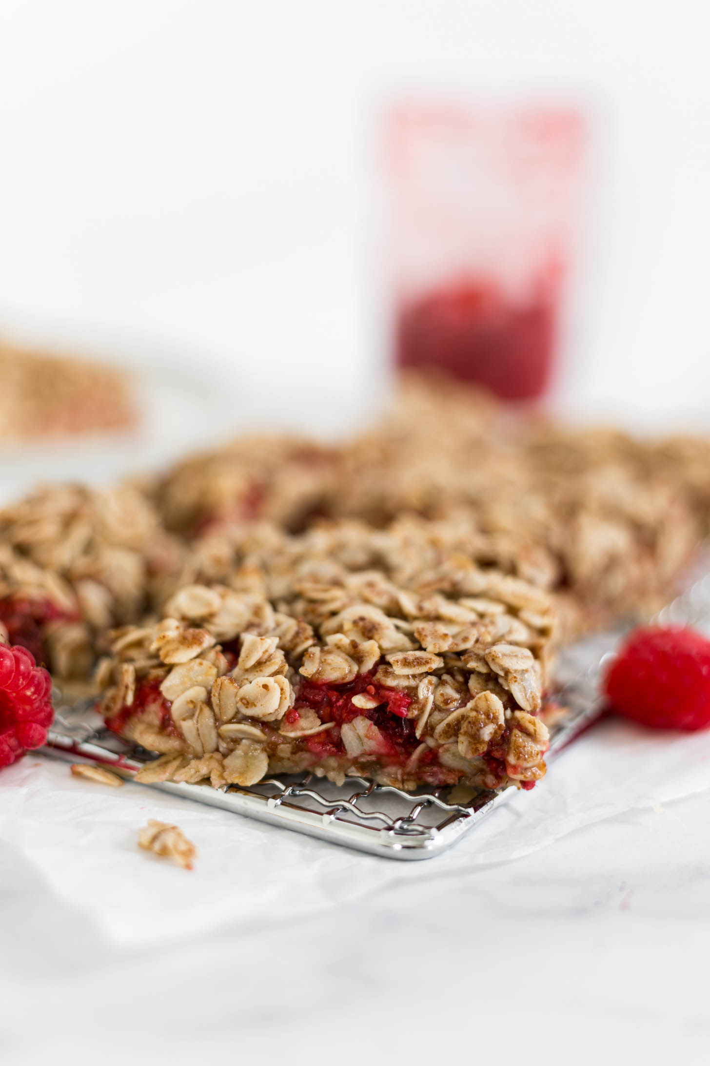 Raspberry bars cut into slices on a metal wire rack.