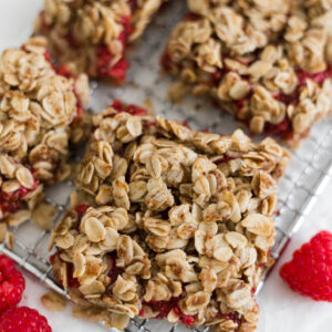 Raspberry Oatmeal Bars sit on a small wire rack.