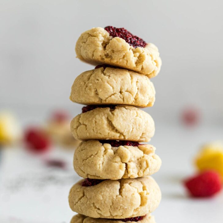 Stack of raspberry thumbprint cookies.