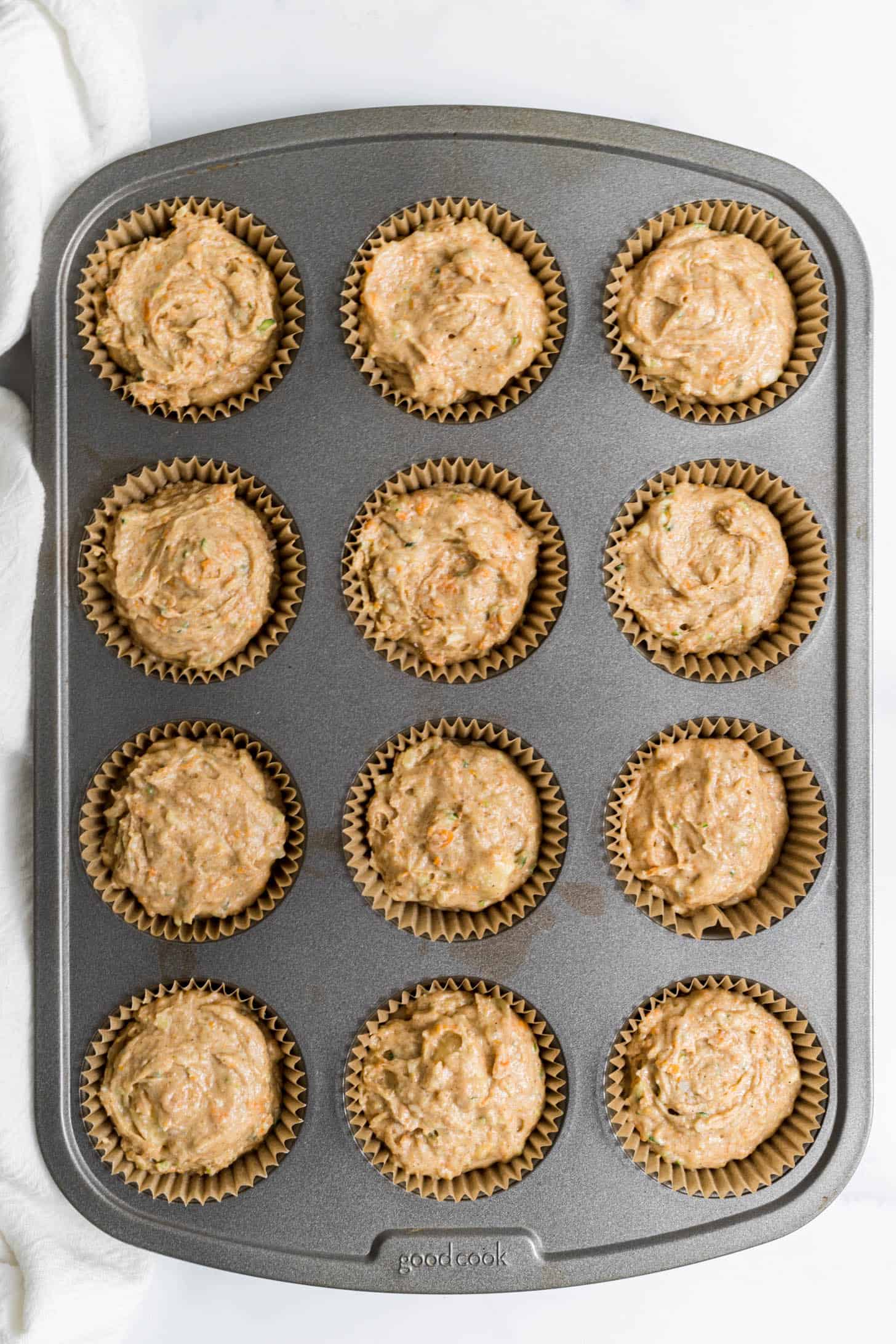 Uncooked muffins in a muffin tin.