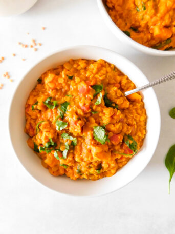 A bowl of Red Lentil Curry With Sweet Potato and Spinach.