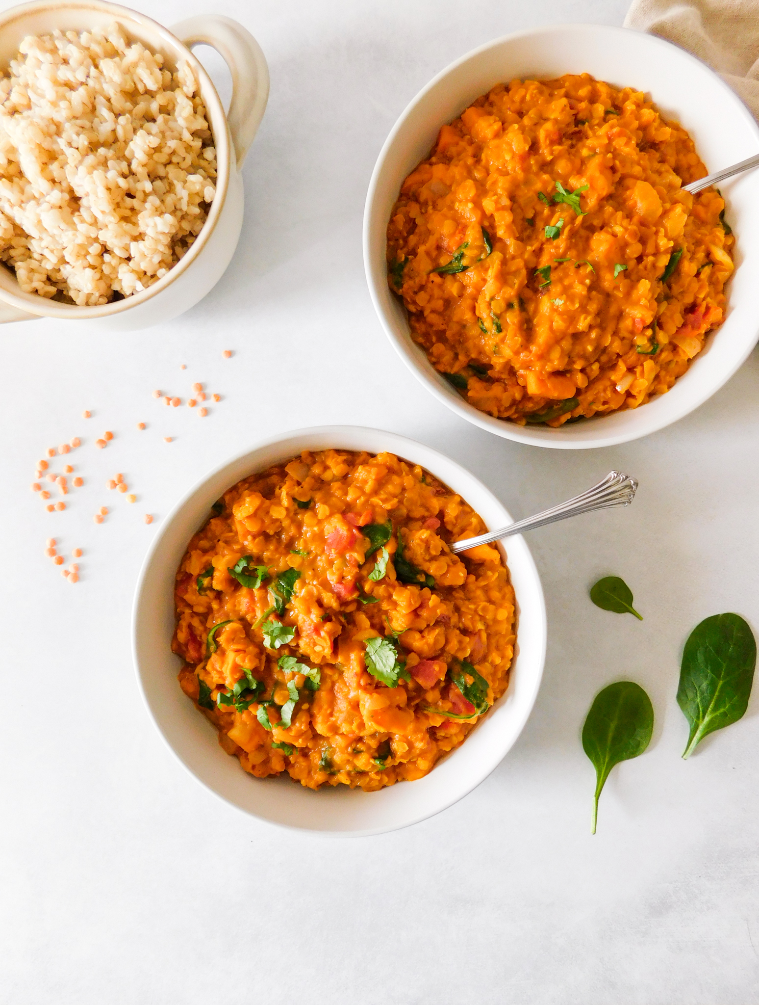 Two bowls of Red Lentil Curry With Sweet Potato and Spinach. 