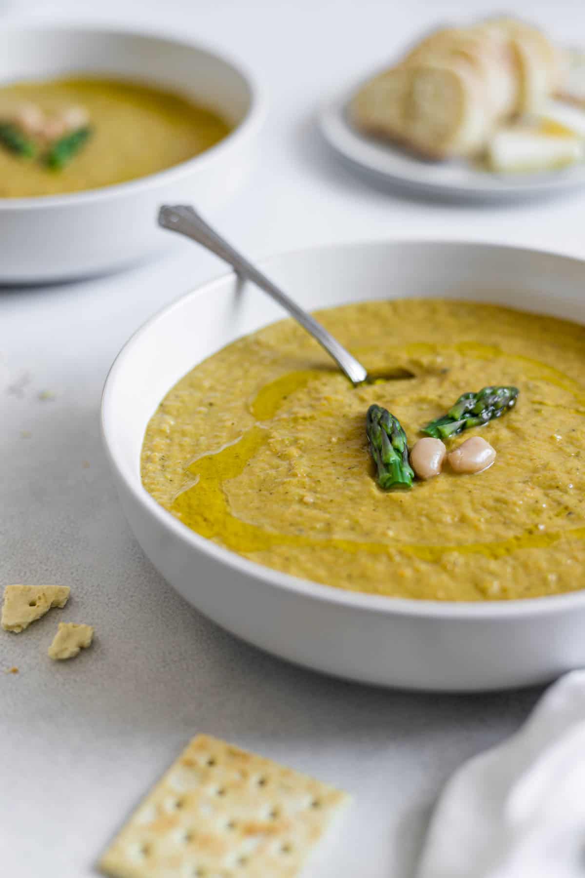 A bowl of asparagus soup with a spoon in it. 