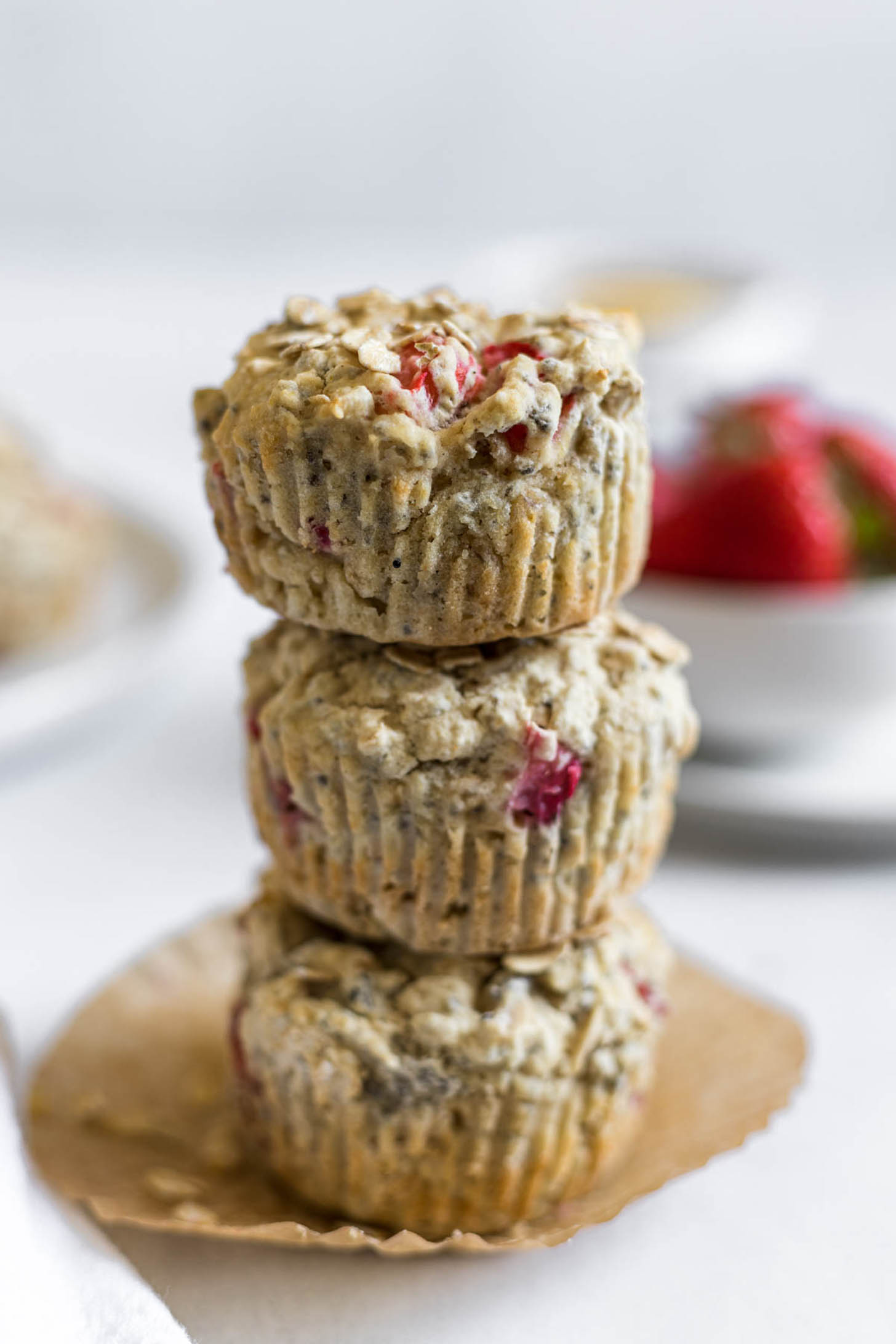 Three strawberry muffins stacked on top of one another.