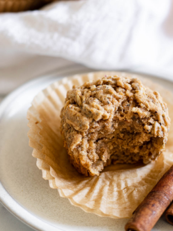 Apple cinnamon vegan muffin with a bite out of it.