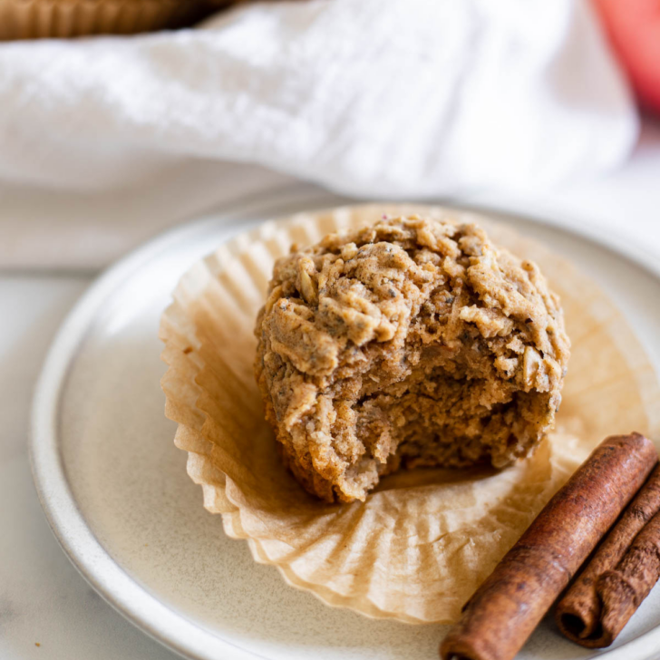 Apple cinnamon vegan muffin with a bite out of it.