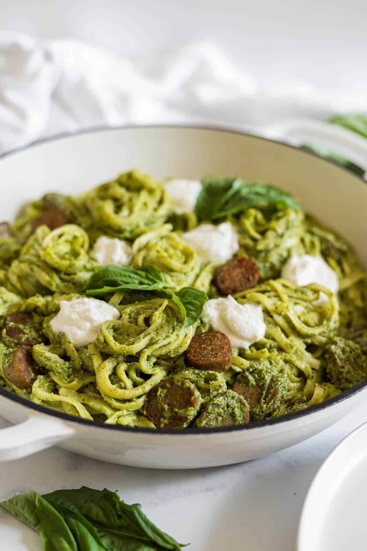 A side view of pesto ricotta pasta in a braiser.