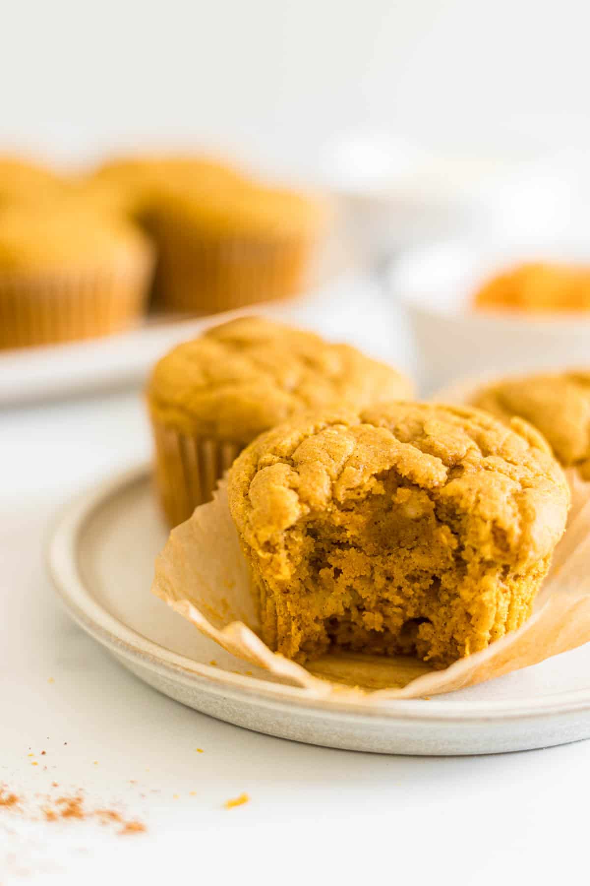 A close up image of a pumpkin muffin with a bite out of it. 