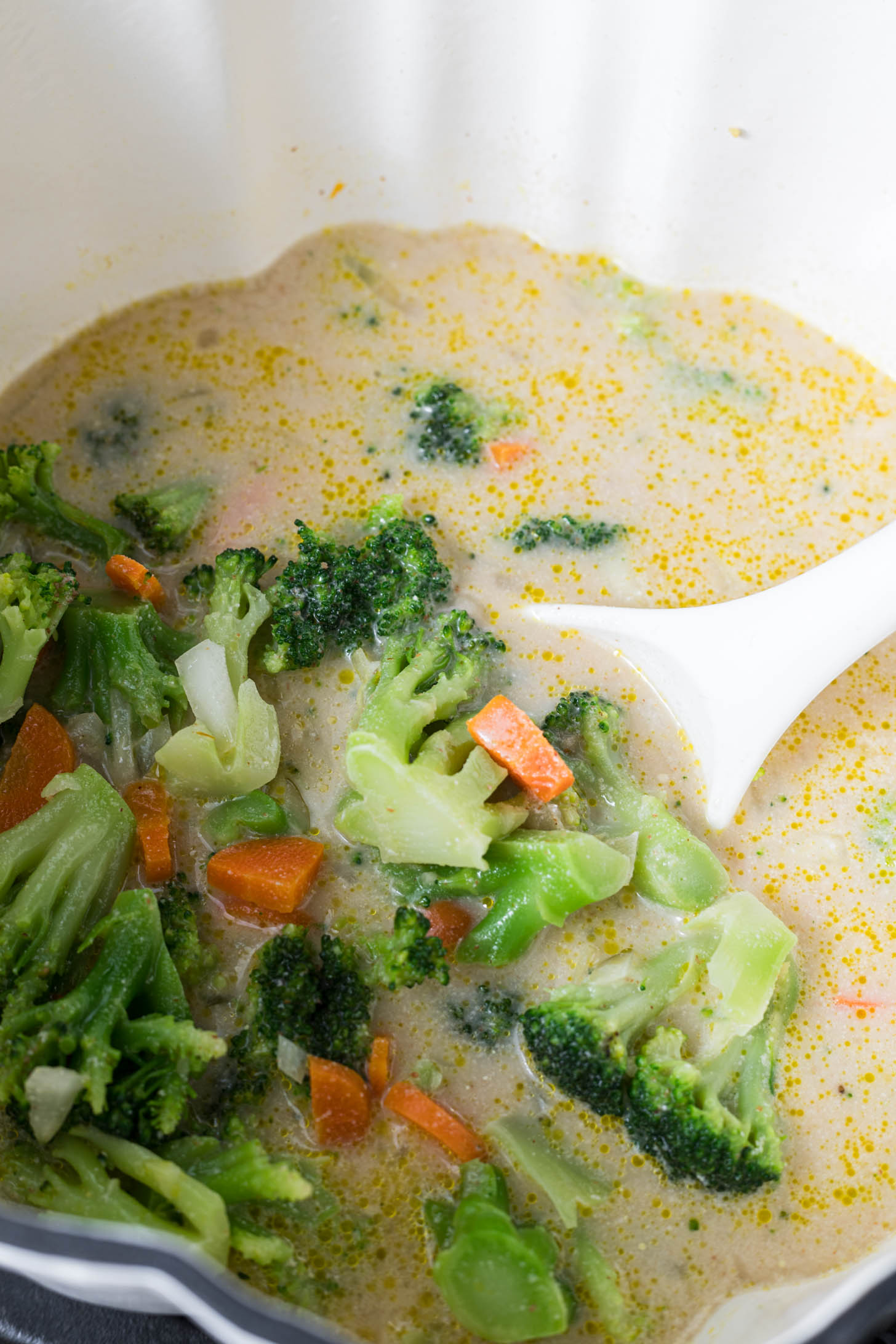 Almond milk and vegetable broth have been added to the vegetable mix in the pot.