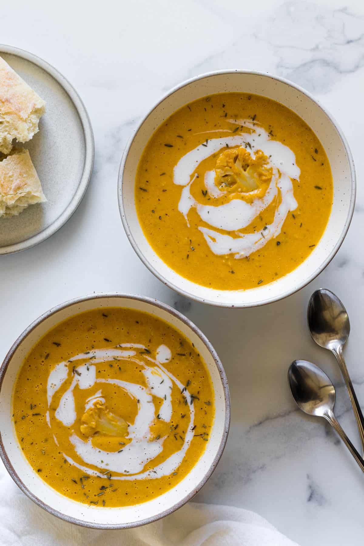 Two bowls of cauliflower pumpkin soup. 