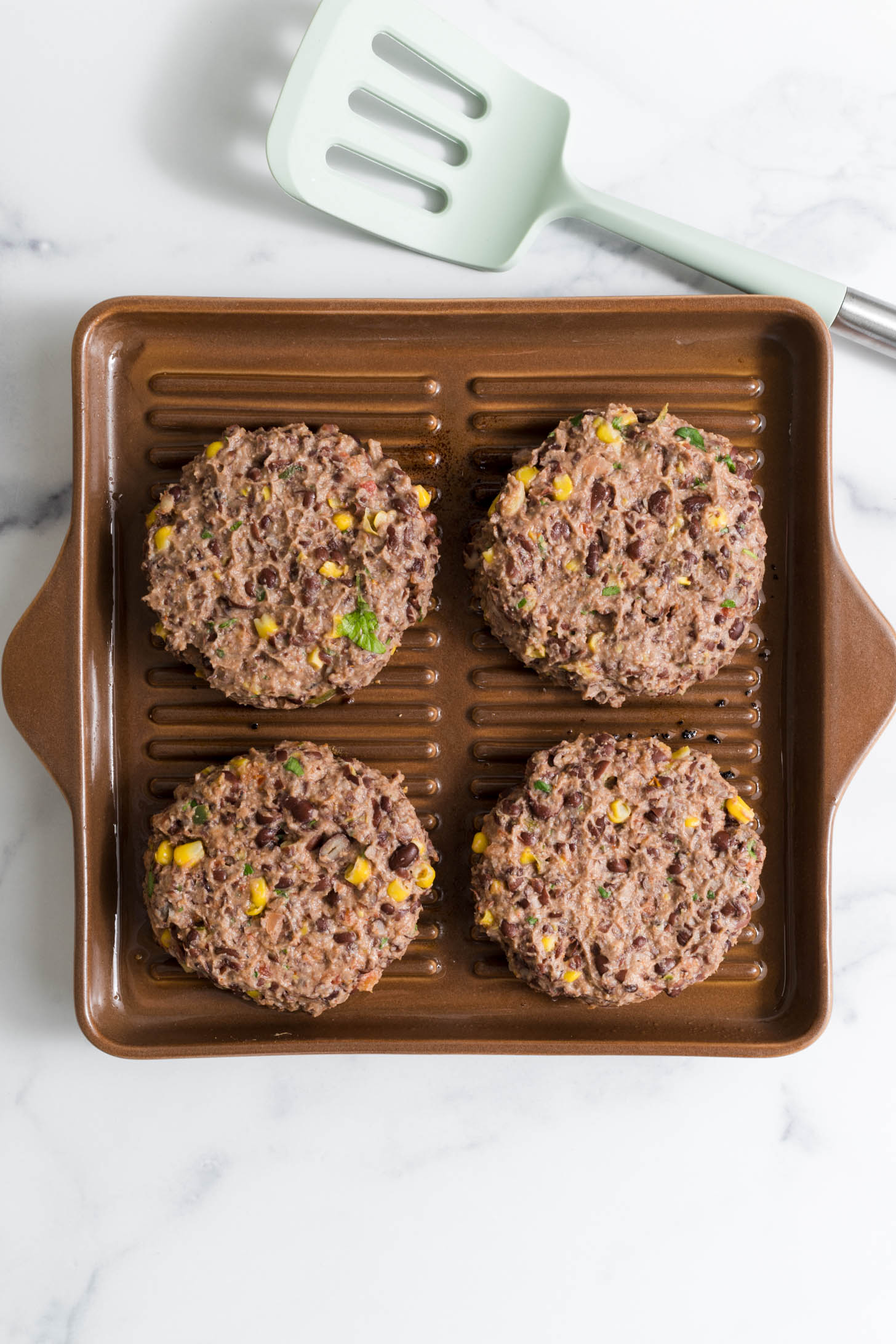 Raw burgers on the grill pan.