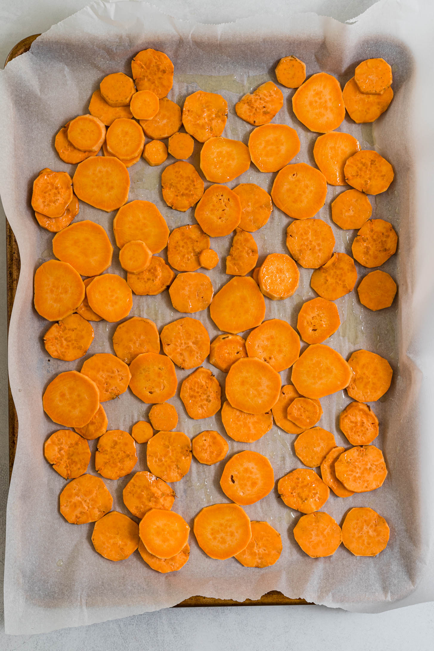 Sweet potato rounds on a baking sheet.