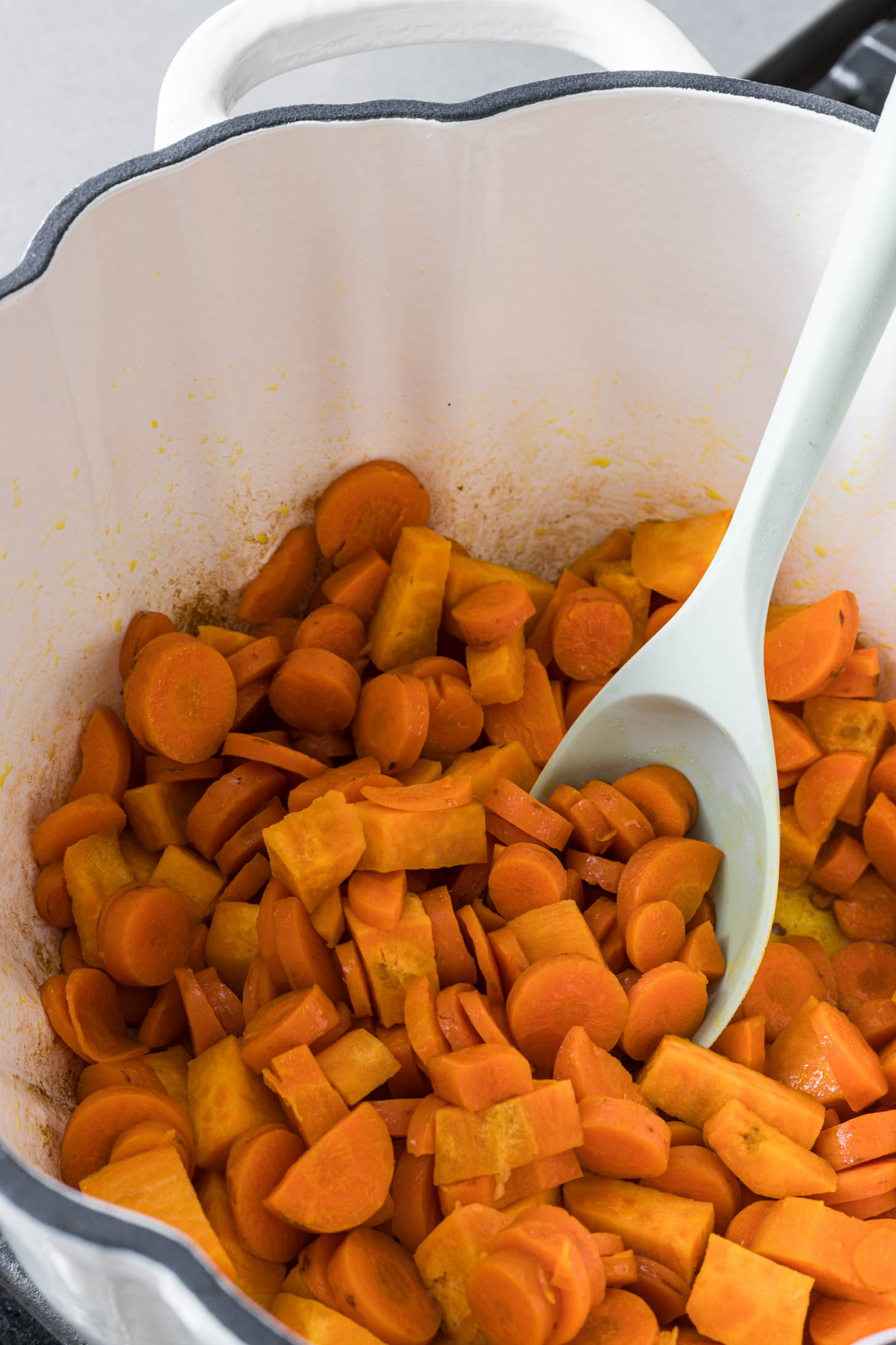 Sweet potato and carrots being sautéed in a dutch oven.