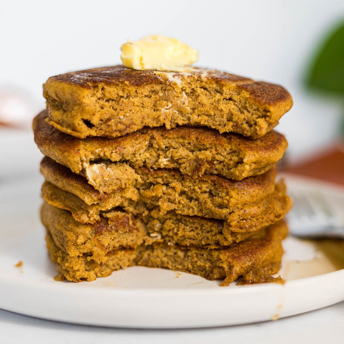 A stack of pumpkin pancakes that are cut down the center.